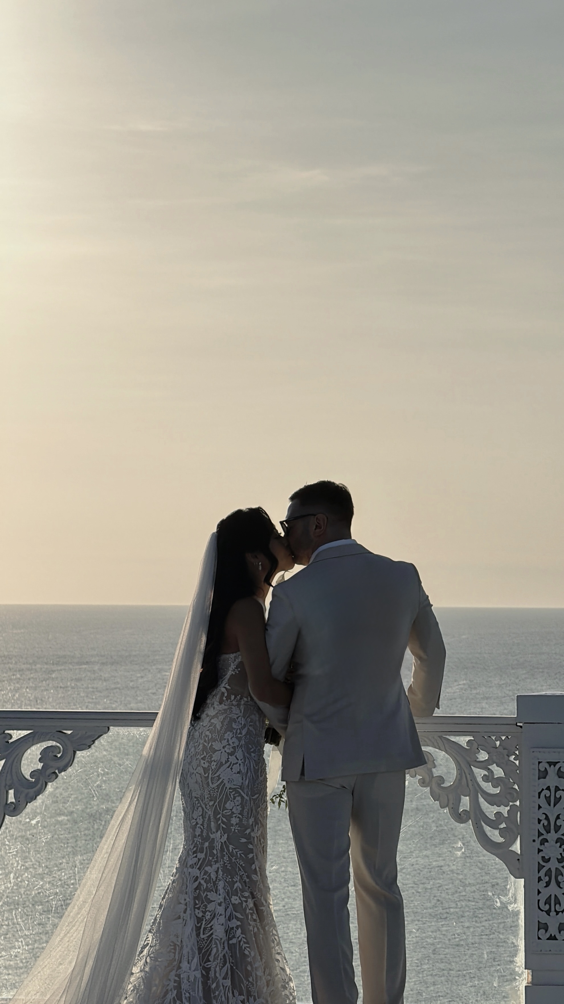 Couple kissing on a clifftop at golden hour